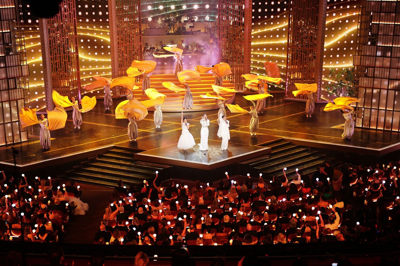 '골든' 무대의 후반부. 이재, 레이 아미, 오드리 누나가 대한제국 당시의 복장에 영감받은 옷을 입고 노래를 부른다. 뒤에 선 무용수들은 혼문을 상징하는 황금 깃발을 휘두르며 군무를 추고 있다. EPA=연합뉴스