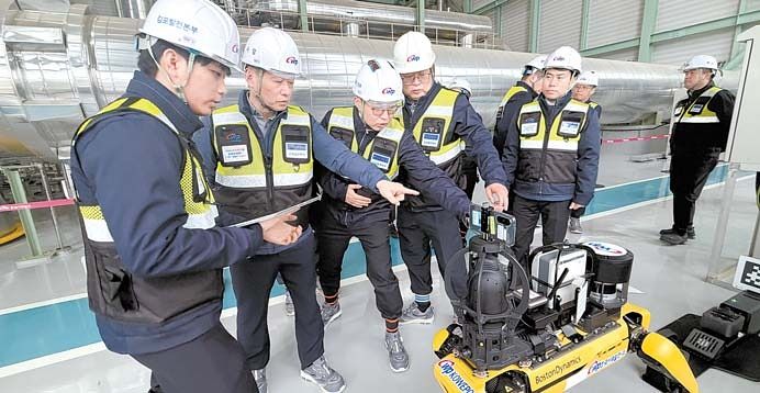 이정복 한국서부발전 사장(왼쪽 두 번째)이 한국형 가스터빈이 설치된 김포발전본부의 발전설비 감시 업무에 투입된 지능형 자율점검 4족 보행 로봇을 점검하고 있다. [사진 한국서부발전]