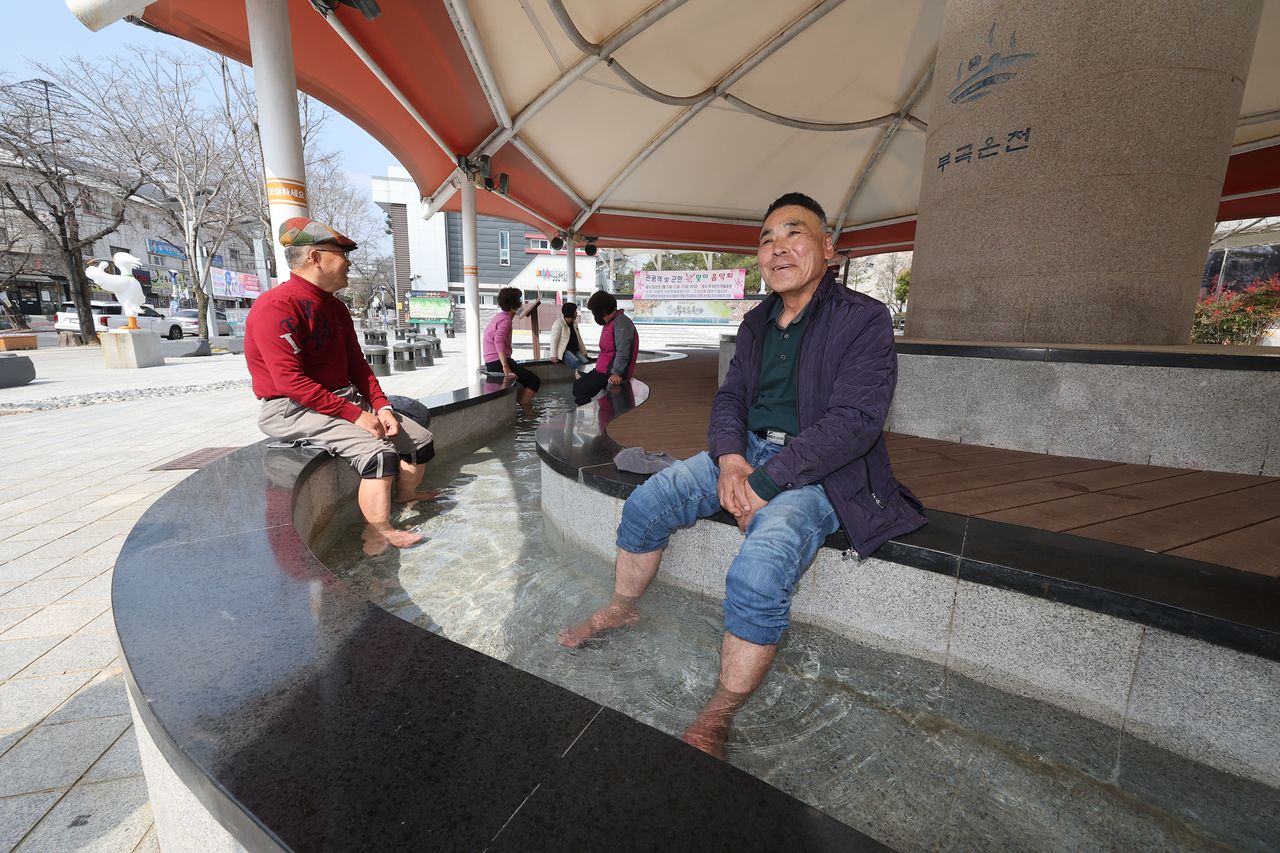 경남 창녕군 부곡온천 한울공원 족욕체험장에서 지난 17일 주민들이 노천 온천 족욕을 즐기며 이야기를 나누고 있다. 송봉근 객원기자