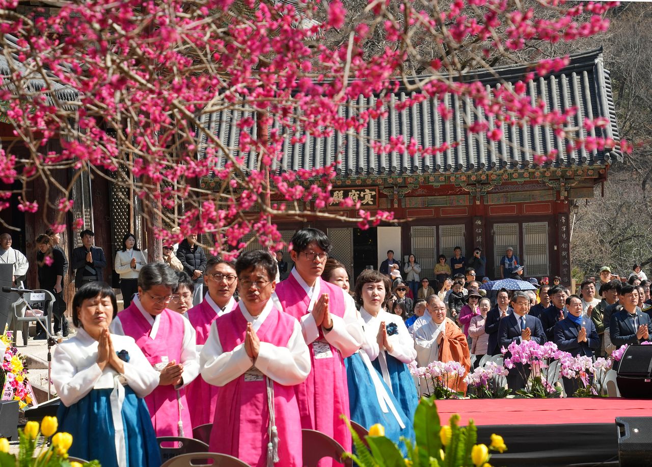 봄을 알리는 홍매화가 활짝 핀 지난 21일 전남 구례군 지리산 화엄사에서 열린 제6회 홍매화 들매화 프로사진 및 휴대폰사진 콘테스트 개막식에서 주지 우석스님 등 참석자들이 합장하고 있다. 연합뉴스