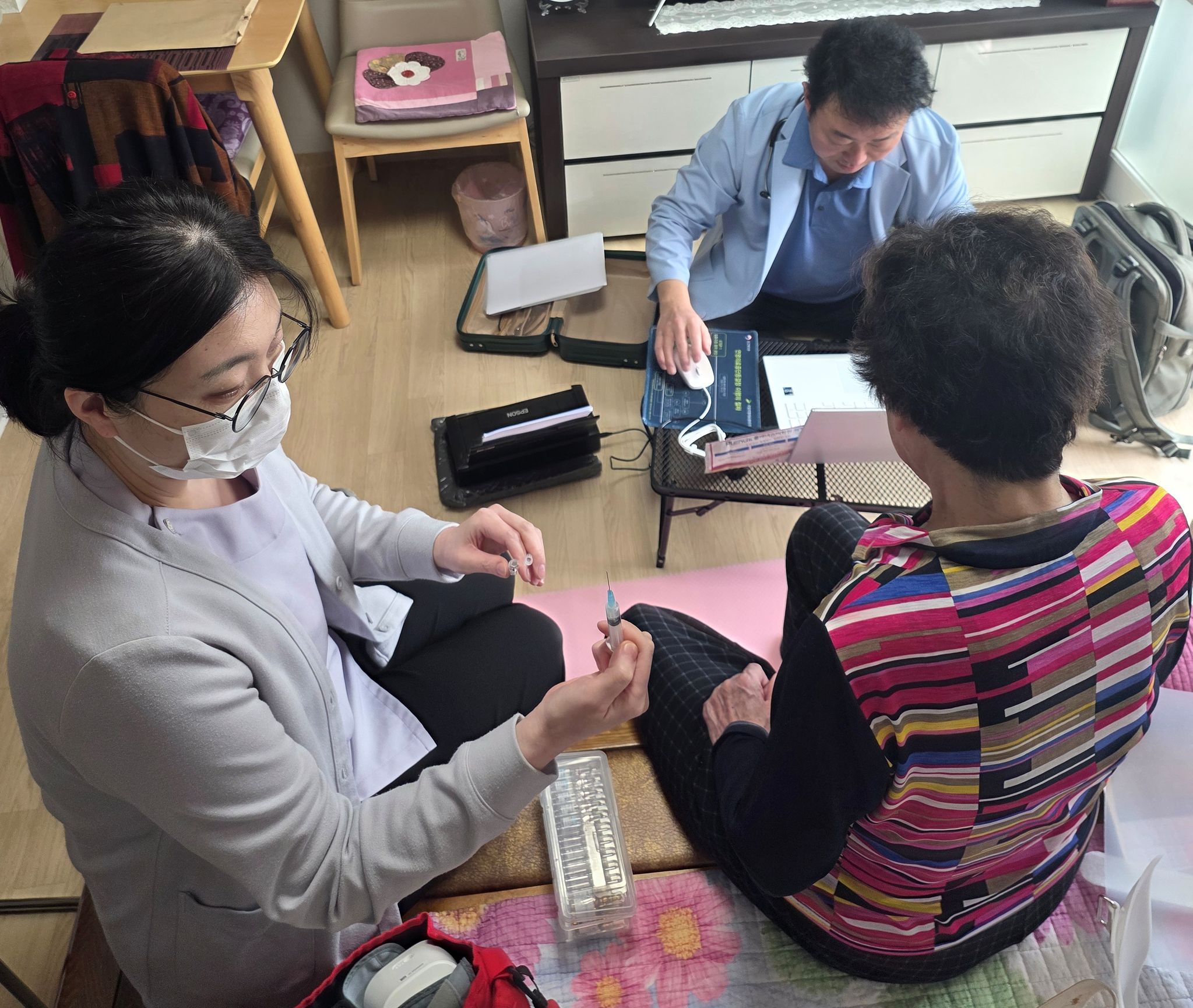 경기도 의정부 편한자리의원 노동훈 원장(오른쪽 위)과 간호사가 27일 척추압박골절 환자 집을 방문해 진료하고 있다. 이 환자는 통합돌봄 전면 시행 첫날 수혜자이다. 사진 편한자리의원