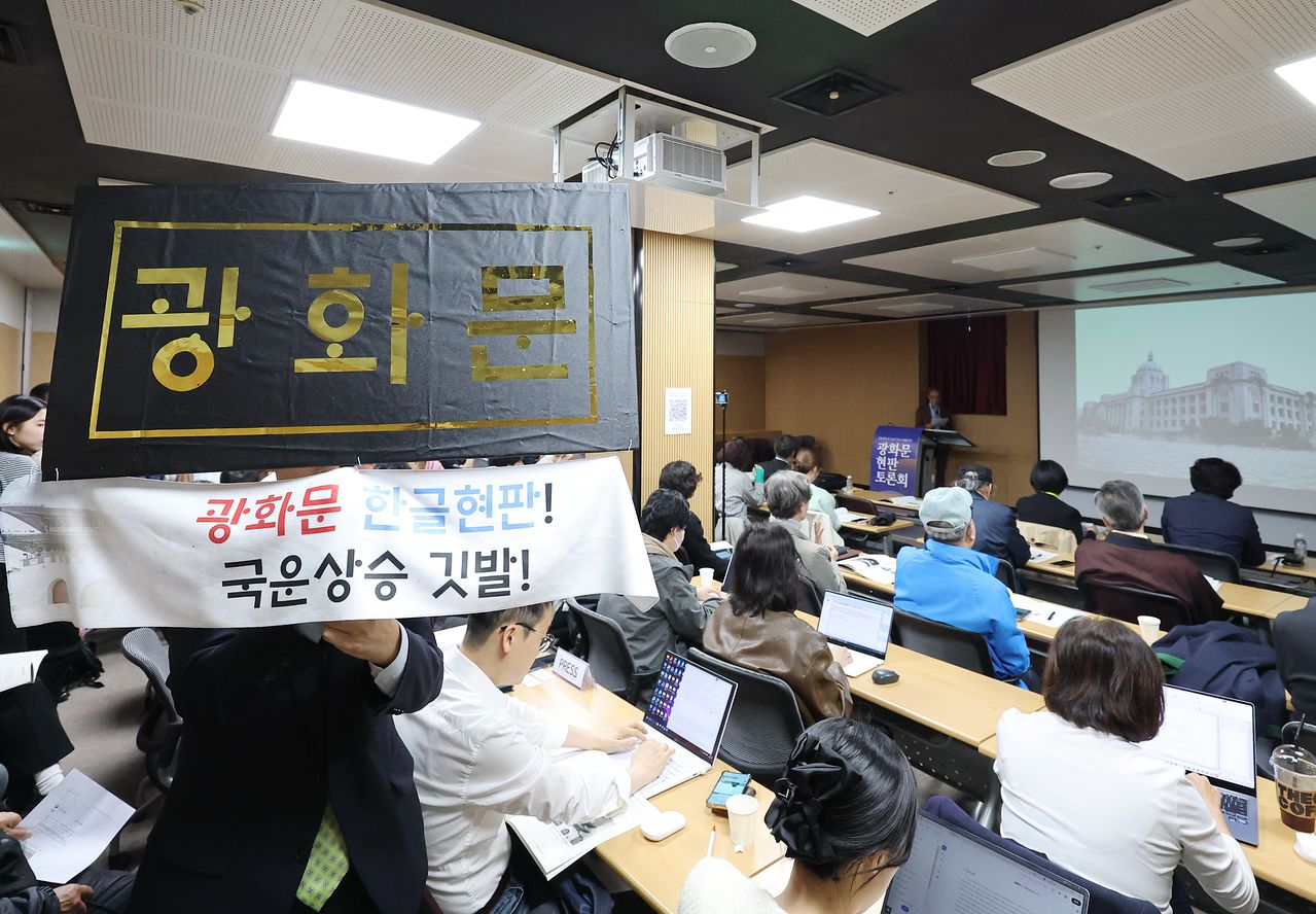 31일 서울 종로구 대한민국역사박물관에서 열린 '광화문 현판 토론회'에서 한 참석자가 한글로 쓴 광화문 문구를 들고 있다. 이번 토론회는 광화문 한글 현판 추가 설치에 대한 주요 입장 및 논거를 위해 마련됐다. 연합뉴스