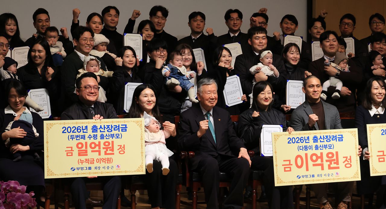 이중근 부영그룹 회장이 지난달 5일 서울 중구 세종대로 부영태평빌딩에서 열린 2026년 시무식 및 출산장려지원 행사에서 출산 장려금을 지급받은 직원 가족들과 기념사진을 촬영하고 있다. 연합뉴스