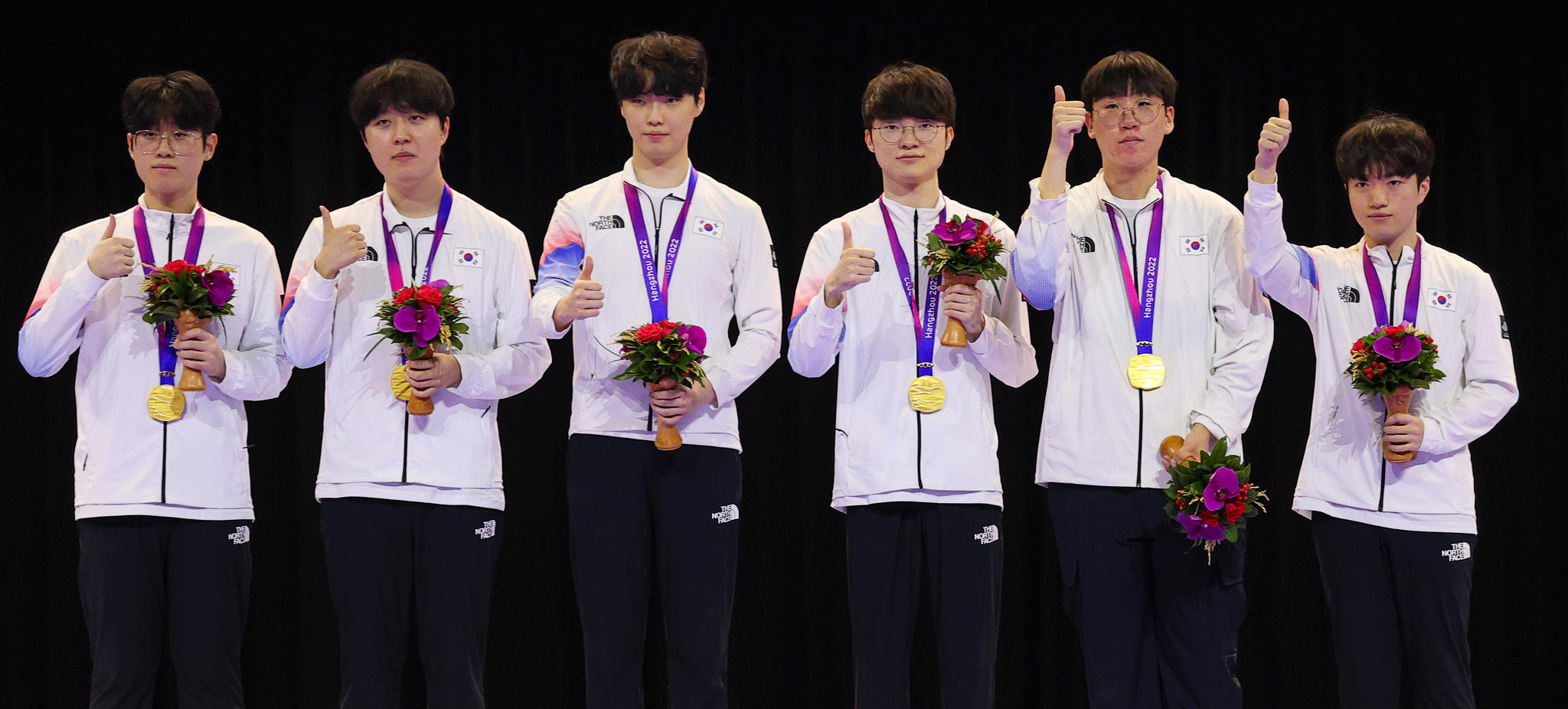 항저우 아시안게임 e스포츠 리그 오브 레전드(LoL)에서 금메달을 딴 한국 선수들이 시상대에 올라 포즈를 취하고 있다. 왼쪽부터 '제우스' 최우제, '카나비' 서진혁, '쵸비' 정지훈, '페이커' 이상혁, '룰러' 박재혁, '케리아' 류민석. 연합뉴스