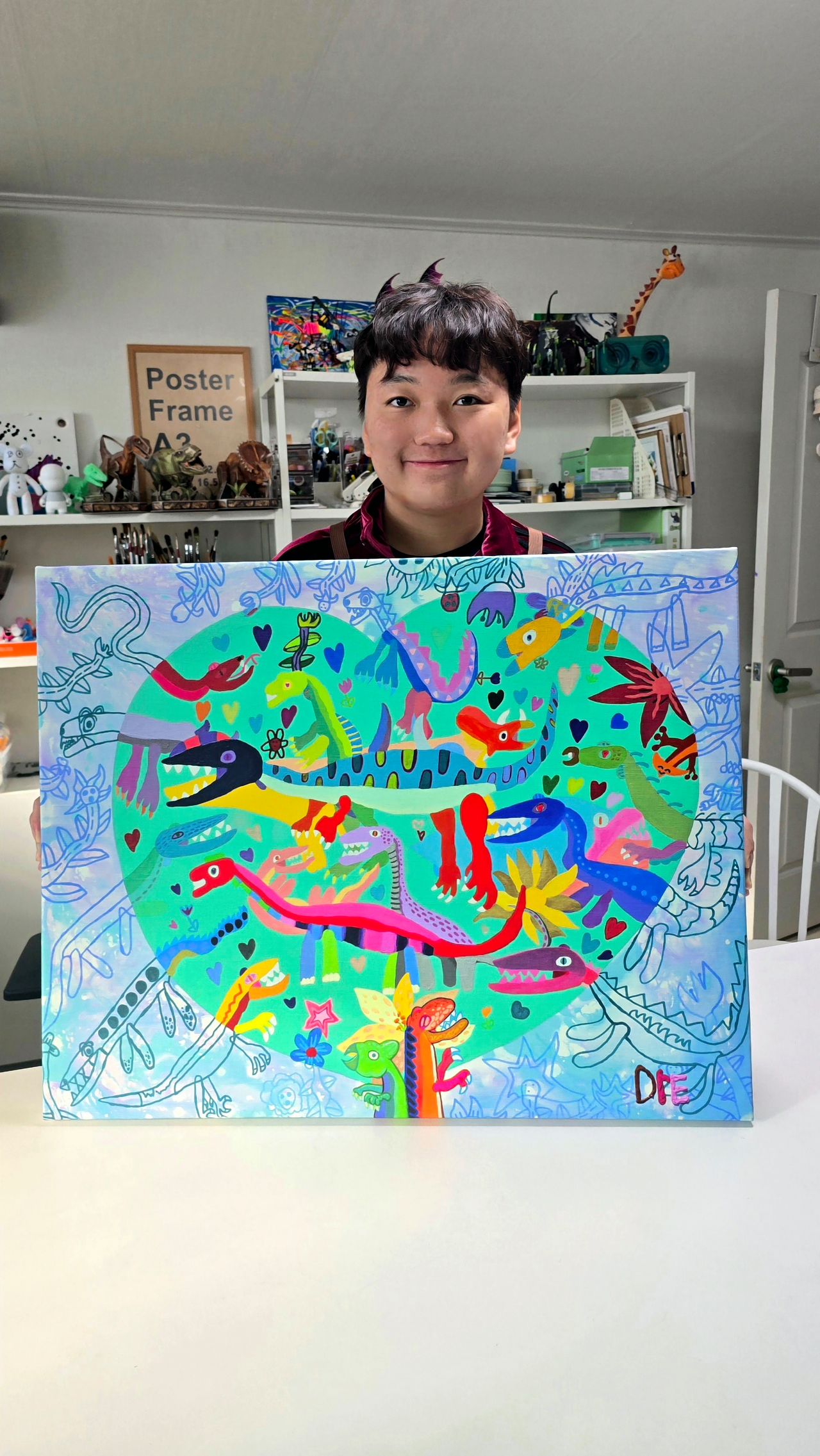 안군이 공룡 그림을 들어 보여주고 있다. 화려한 색감이 눈길을 끈다. 사진 가족