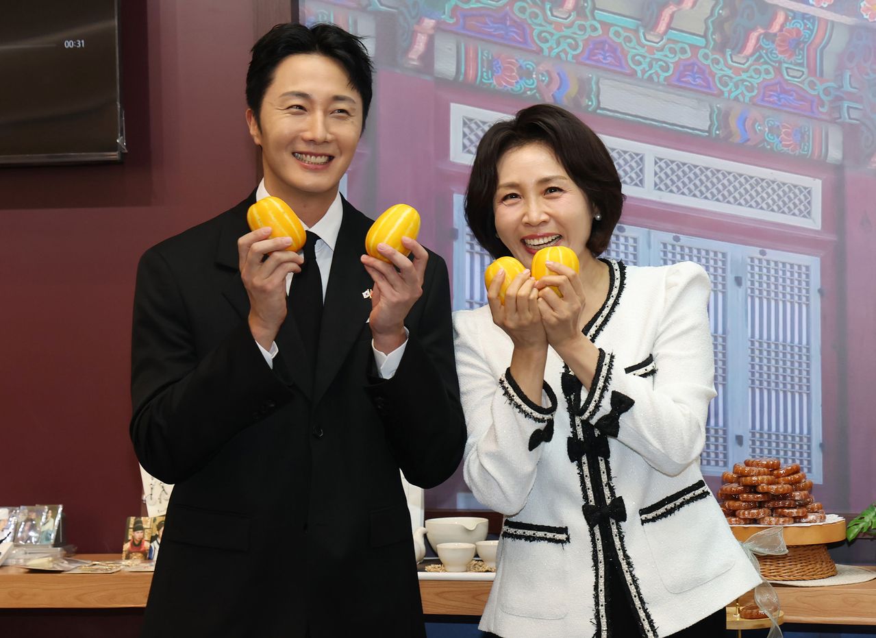 이재명 대통령과 베트남을 국빈 방문 중인 김혜경 여사가 23일(현지시간) 하노이 롯데몰에서 열린 K문화관광대전에서 배우 정일우와 참외를 들고 있다. 연합뉴스