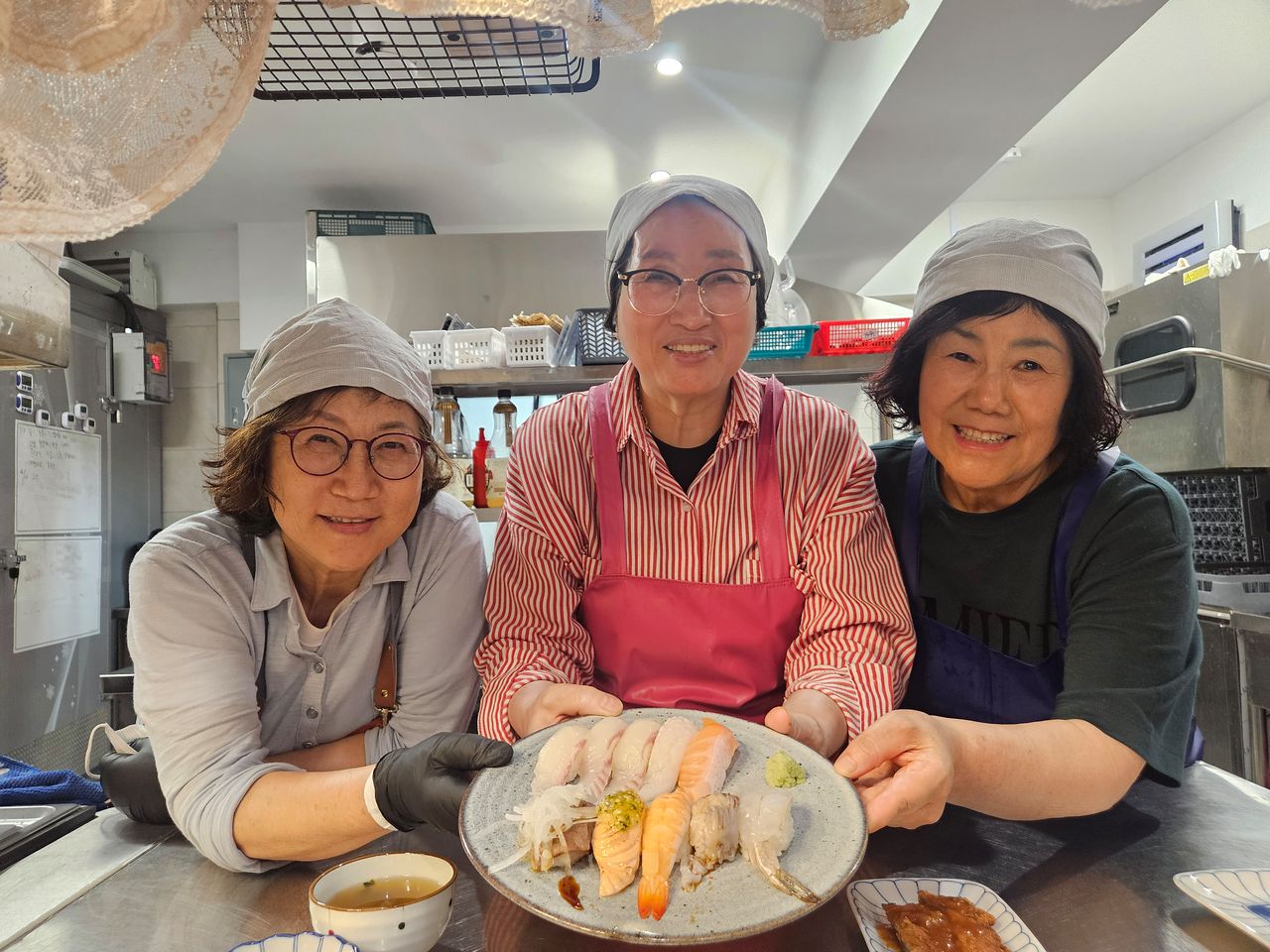 지난 20일 오전 울산시 남구 신정동 초밥집 스시은에서 공용자(74)·장정희(71)·백현자(63)씨가 자신들이 만든 초밥을 앞에 두고 활짝 웃고 있다. [사진 울산 남구시니어클럽]