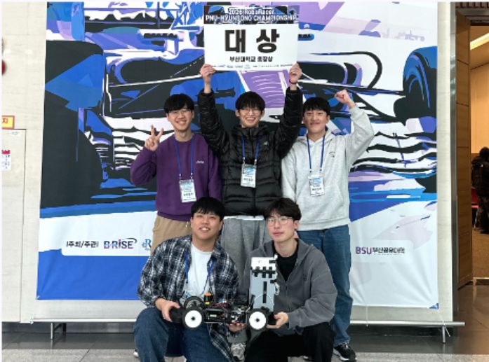 지난 1월 부산 벡스코에서 열린 자율주행 경진대회에서 대상을 차지한 부산대 기계공학과 학생들이 모형 자동차를 들어 보이고 있다. 부산대는 LG전자와 한화에어로스페이스 등 대기업과 계약학과를 연이어 개설하고 있다. 사진 부산대