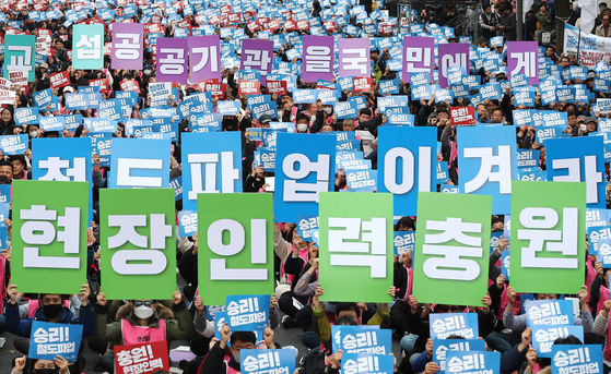 철도노조 파업 나흘째인 2019년 11월 23일 오후 서울 종로구 우정국로에서 열린 공공운수노조 결의대회에서 참가자들이 피켓을 들고 구호를 외치고 있다.   이들은 현장 인력 충원, 임금피크제 폐지 등을 촉구했다. 연합뉴스 