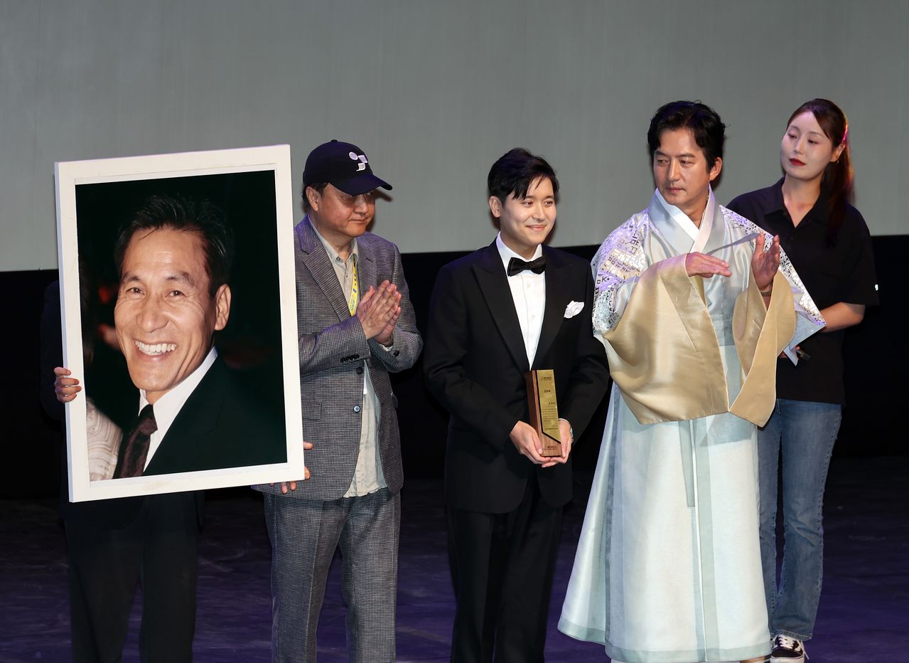29일 전북 전주시 한국소리문화의전당 모악당에서 열린 제27회 전주국제영화제 개막식에서 조직위원회가 고 안성기 배우에게 특별공로상을 시상하고 있다. 이 상은 그의 아들 필립씨가 참석해 대리 수상했다. 연합뉴스