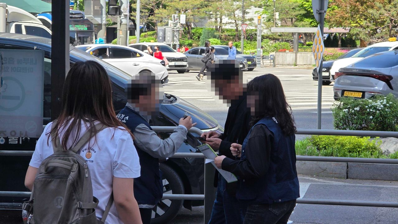서울시 구청 단속원들이 금연구역에서 액상형 전자담배를 피운 남성에게 과태료 면제 조건에 대해 설명하고 있다. 김창용 기자