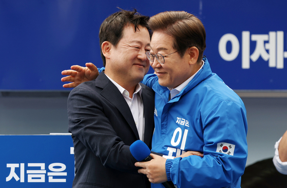 이재명 더불어민주당 당시 대선후보가 지난해 5월 17일 광주광역시 서구 김대중컨벤션센터 광장에서 열린 집중 유세에서 이 후보 지지를 선언한 김용남 당시 전 의원 무대에서 포옹하고 있다. 연합뉴스