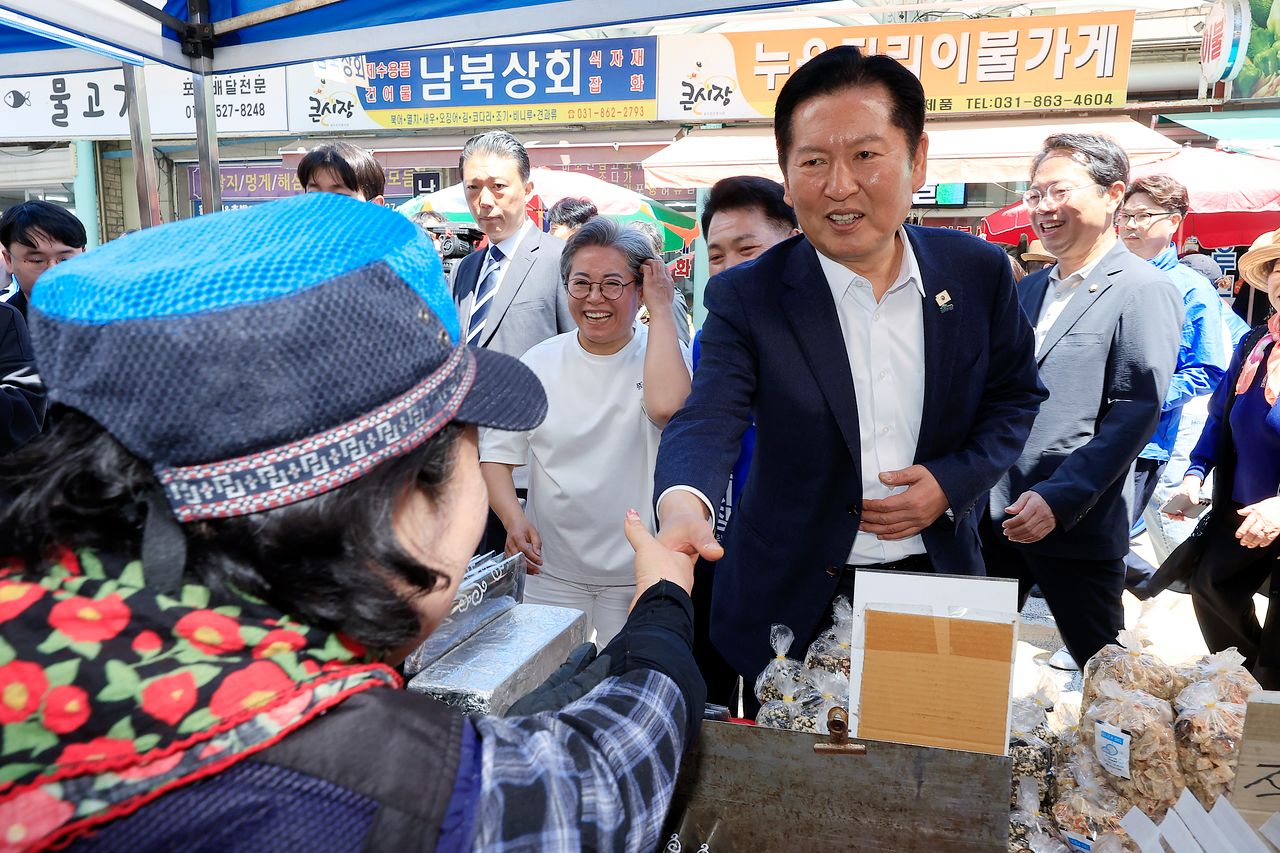 정청래 더불어민주당 대표가 5일 경기도 동두천시 중앙로 동두천큰시장을 찾아 상인과 인사를 나누고 있다. 뉴스1