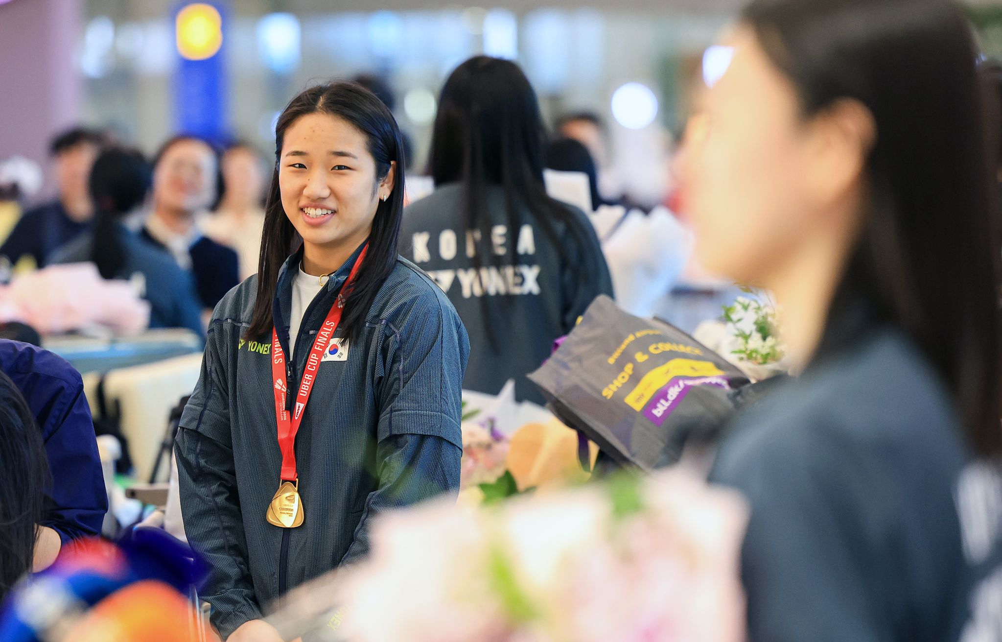 인천국제공항 입국장에서 열린 귀국 기자회견에서 동료의 인터뷰를 흐뭇한 미소와 함께 바라보는 안세영. 뉴스1