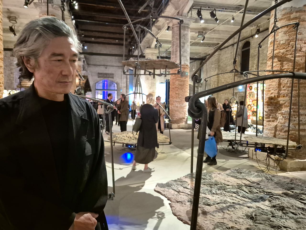 본전시에 참가한 한국계 미국 작가 마이클 주. 화석판을 천칭처럼 매단 〈우리 주변에서 증발하는 것들〉 옆에 섰다. 베니스=권근영 기자