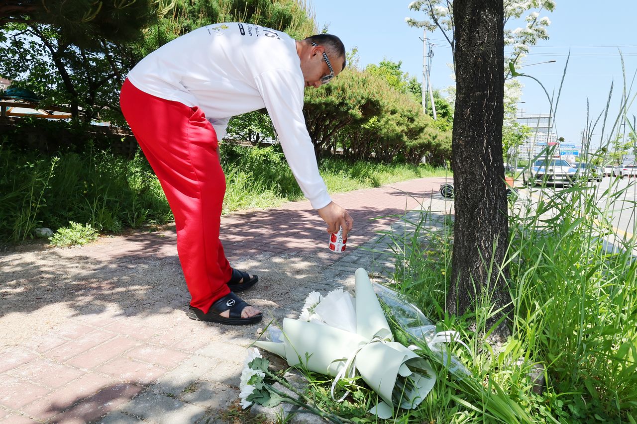 6일 오후 광주 광산구 월계동 한 보행자도로에서 한 시민이 음료수를 내려놓고 있다. 이곳에서는 어린이날인 전날 오전 살인 혐의 등을 받는 장모(24)씨가 휘두른 흉기에 여고생과 남고생이 찔려 숨지거나 다쳤다. 연합뉴스