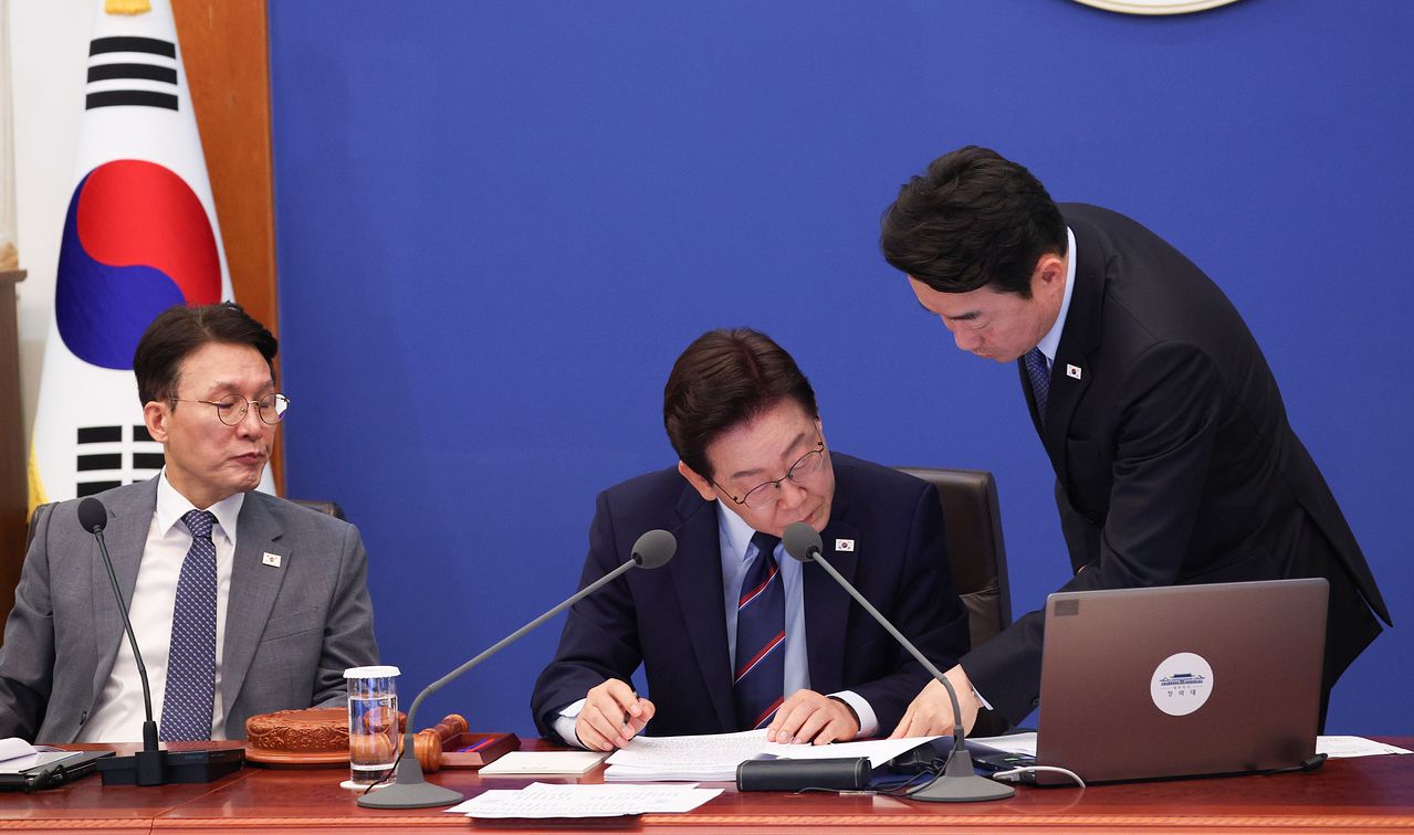  이재명 대통령이 12일 청와대에서 열린 제21회 국무회의에서 김민석 국무총리(왼쪽), 강훈식 대통령비서실장(오른쪽)과 함께 자료를 보고 있다. [청와대사진기자단]