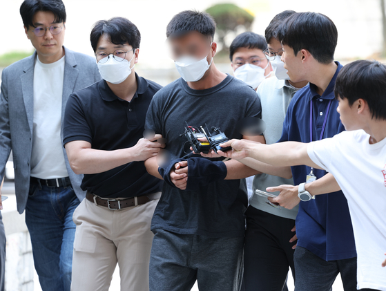 그룹 BTS 정국 등 국내 재력가들 자산을 탈취한 혐의를 받는 해킹조직 총책 중국 국적 전모씨가 지난해 8월 서울 서초구 서울중앙지법에서 열린 구속 전 피의자 심문(영장실질심사)에 출석하고 있다. 연합뉴스