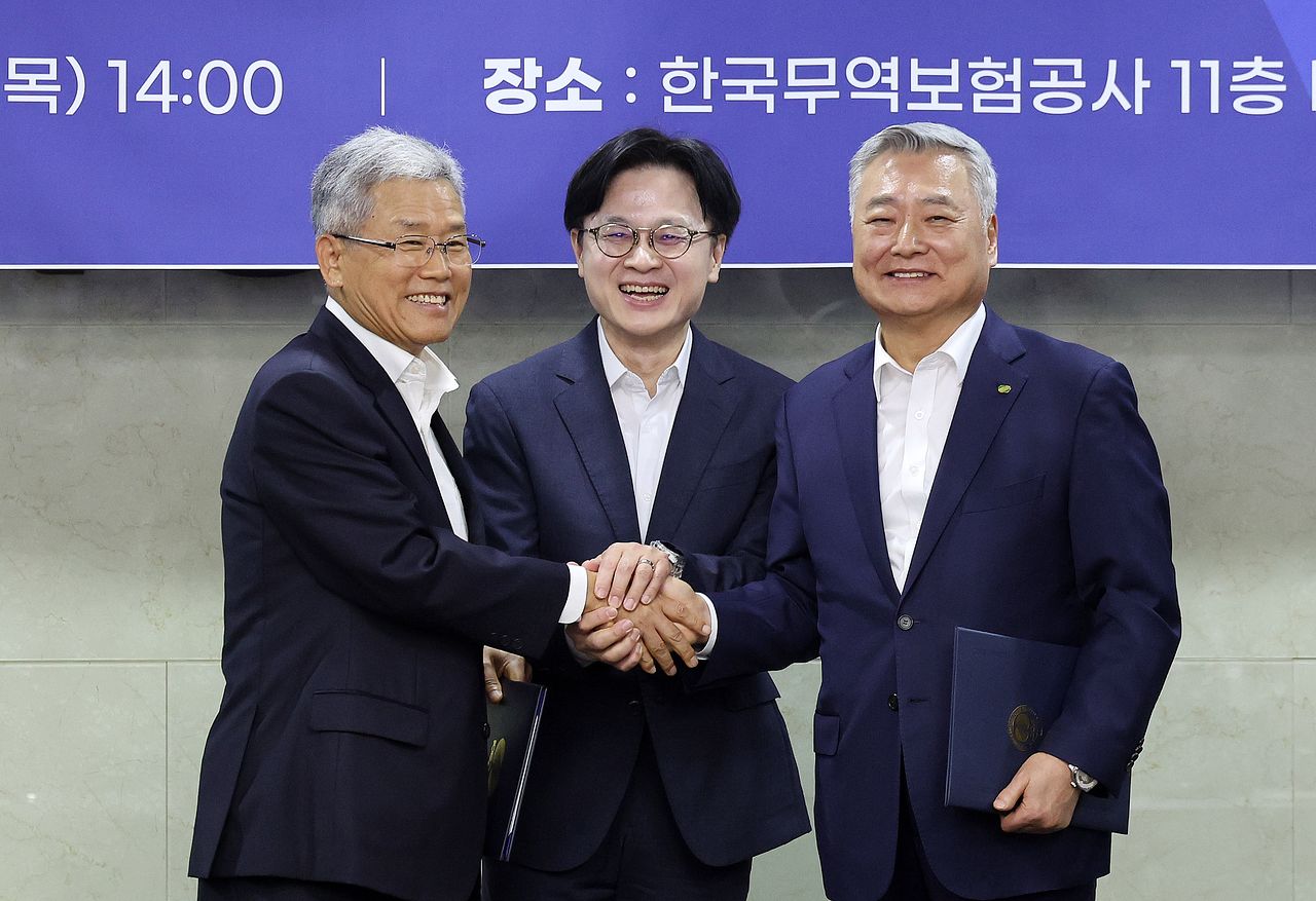 14일 중구 무역보험공사에서 열린 원전수출 전략적 파트너십 협약식에서 김정관 산업통상부 장관(가운데)이 협약서에 서명한 김동철 한국전력공사 사장(왼쪽)과 김회천 한국수력원자력 사장과 함께 손을 맞잡고 있다. 뉴스1