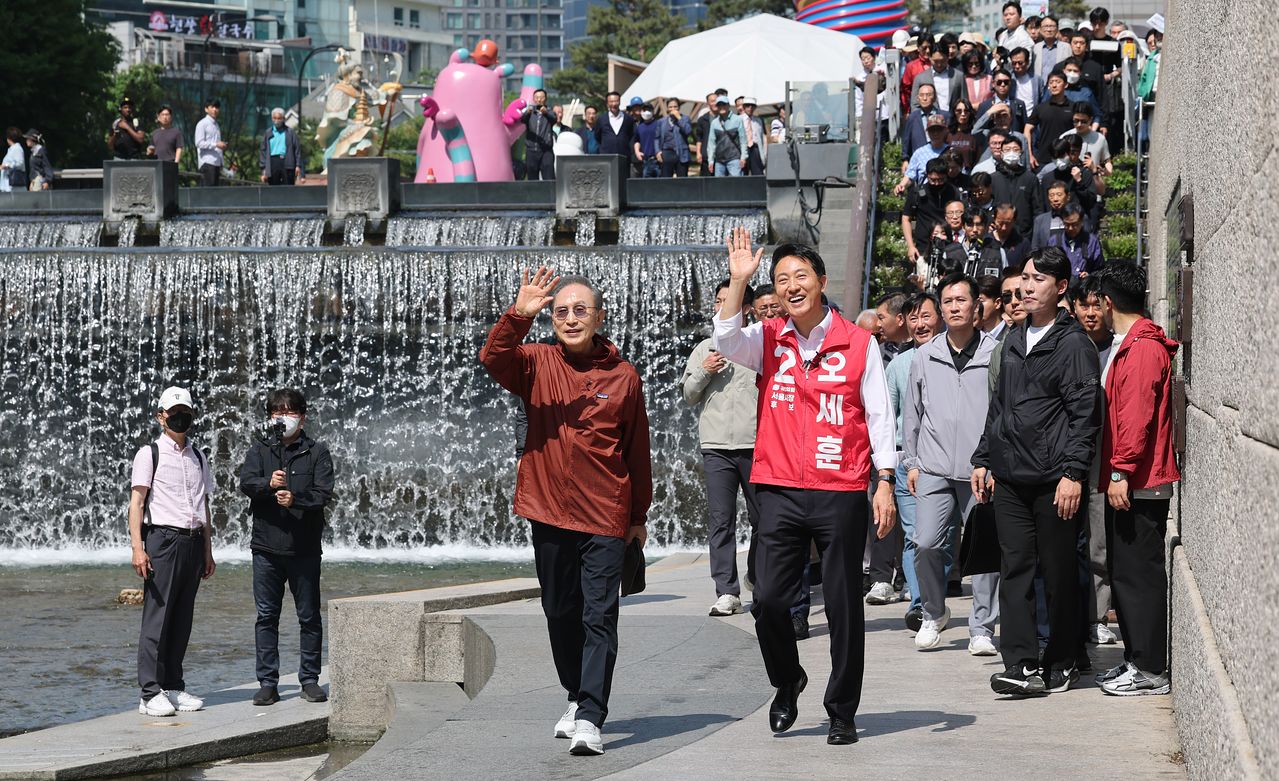 오세훈 국민의힘 서울시장 후보가 15일 서울 청계천에서 만난 이명박 전 대통령과 시민들에게 인사하고 있다. 뉴스1