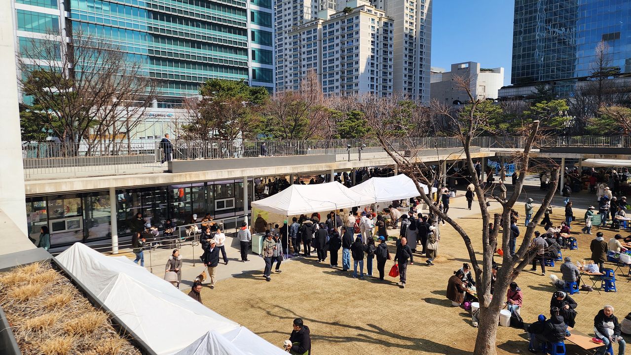텅 빈 잔디 광장 둘레로 지붕만 단정하게 두른 목동 오목공원의 ‘회랑’. 특정한 기능을 억지로 채우지 않은 여백 덕분에 주말이면 활기찬 농부 시장으로 유연하게 변신한다. [사진 조성익]