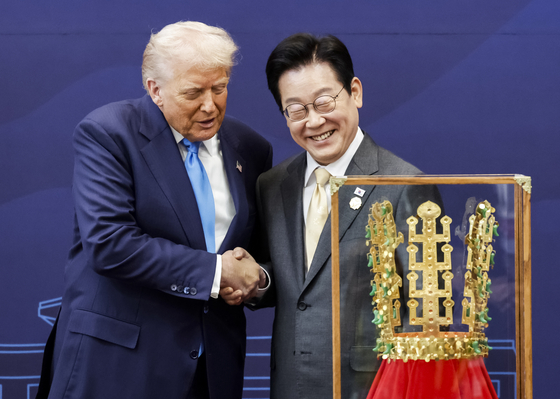 이재명 대통령이 지난해 10월 29일 2025 APEC 정상회의를 계기로 국빈 방문한 도널드 트럼프 미국 대통령에게 ‘천마총 금관 모형’을 선물한 뒤 악수하고 있다. 청와대