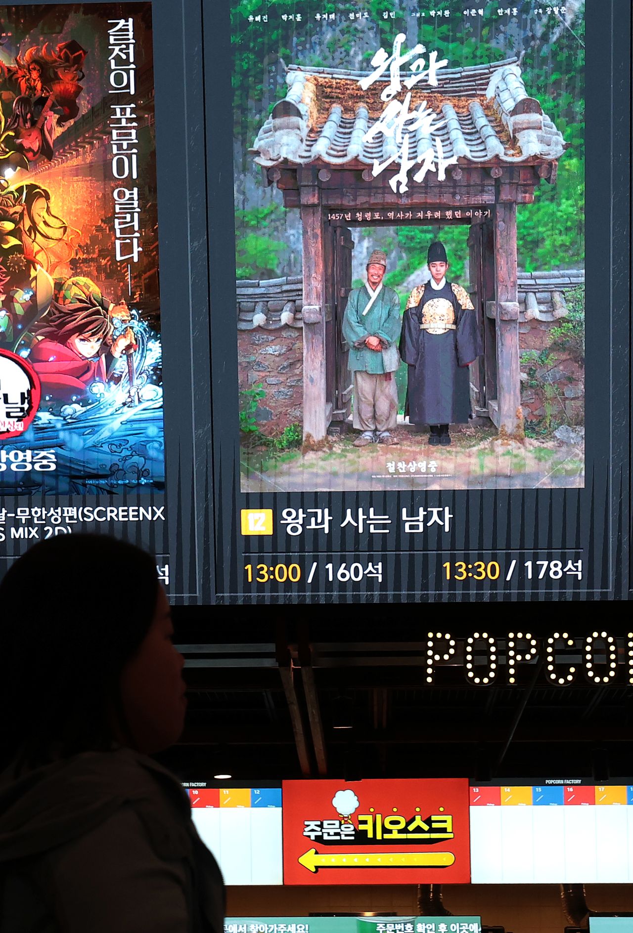 지난 3월 25일 서울 용산구의 한 영화관에서 한 관람객이 영화 '왕과 사는 남자' 포스터 옆을 지나가고 있다. 뉴스1