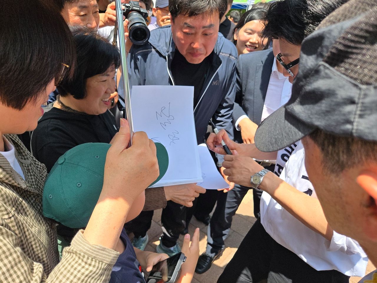지난 16일 부산 만덕동 마을 축제를 찾은 한동훈 무소속 후보에게 사인을 해달라며 시민들이 모여 들었다. 박성훈 기자