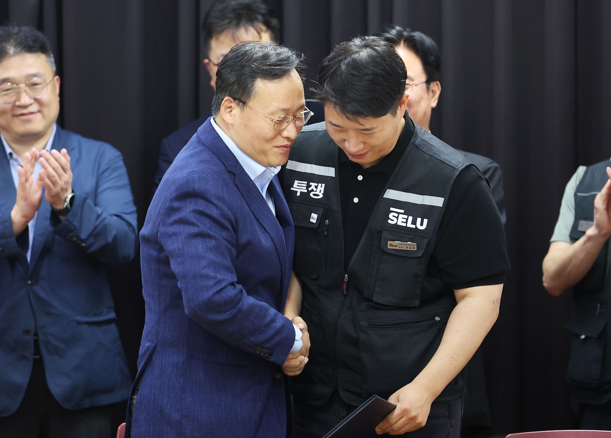 20일 경기도 수원시 장안구 경기고용노동청에서 열린 삼성전자 임금협상을 마친 후 여명구 삼성전자 DS(디바이스솔루션 반도체 사업 담당) 피플팀장과 최승호 삼성그룹 초기업노동조합 삼성전자지부 위원장이 잠정 합의한에 서명한 후 손을 맞잡고 있다. 김성룡 기자