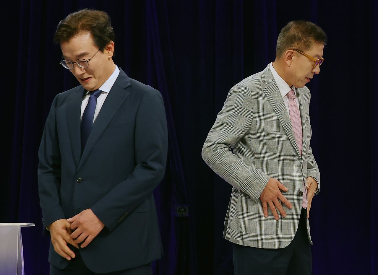 전재수 더불어민주당 부산시장 후보(왼쪽)와 국민의힘 박형준 부산시장 후보가 19일 오후 부산 KNN에서 진행된 부산시장 후보자 토론회에 앞서 악수 한 뒤 자리로 돌아가고 있다. 연합뉴스