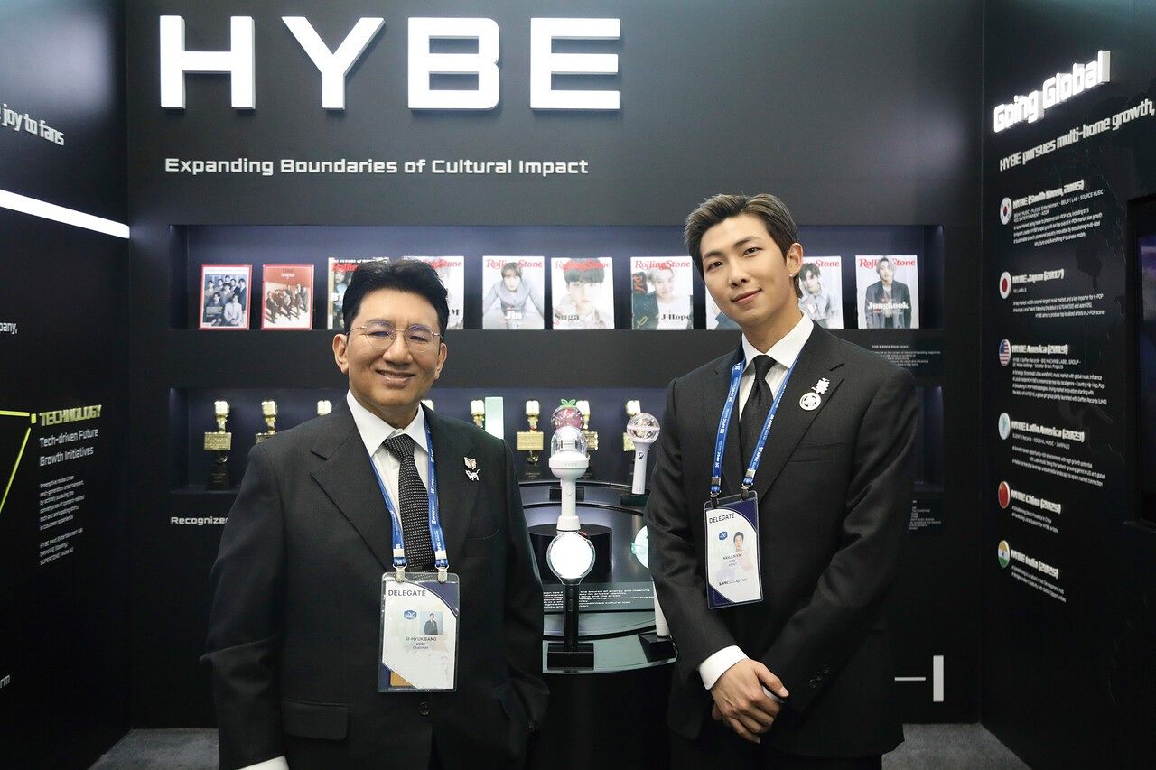 지난해 10월 29일 경주 예술의전당에서 열린 ‘APEC CEO 서밋’ 개회식에서 방시혁(왼쪽) 하이브 의장과 방탄소년단 RM(오른쪽)이 하이브 홍보부스를 관람하고 기념 촬영하고 있다. [연합뉴스]