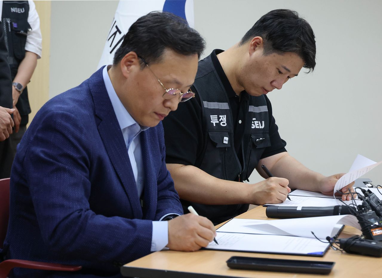 20일 잠정 합의안에 서명하고 있는 여명구 삼성전자 DS 피플팀장(왼쪽)과 최승호 삼성그룹 초기업노동조합 삼성전자지부 위원장. 김성룡 기자