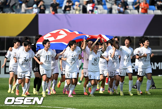 [OSEN=수원, 이대선 기자] 우승컵도, 100만 달러(약 15억 원) 우승 상금도 북한 내고향여자축구단 차지가 됐다. 논란 속 한국에서 열린 결승전에서 내고향은 일본 도쿄 베르디 벨레자를 꺾고 아시아 정상에 올랐다. 경기장 분위기 역시 마지막까지 씁쓸함을 남겼다.내고향은 23일 오후 수원종합운동장에서 열린 2025-2026 아시아축구연맹(AFC) 여자 챔피언스리그(AWCL) 결승전에서 도쿄 베르디를 1-0으로 꺾고 우승을 차지했다. 이날 공식 관중은 2670명이었다.경기 종료 후 내고향여자축구단 선수단이 인공기를 펼치고 기념촬영을 하고 있다. 2026.05.23 /sunday@osen.co.kr