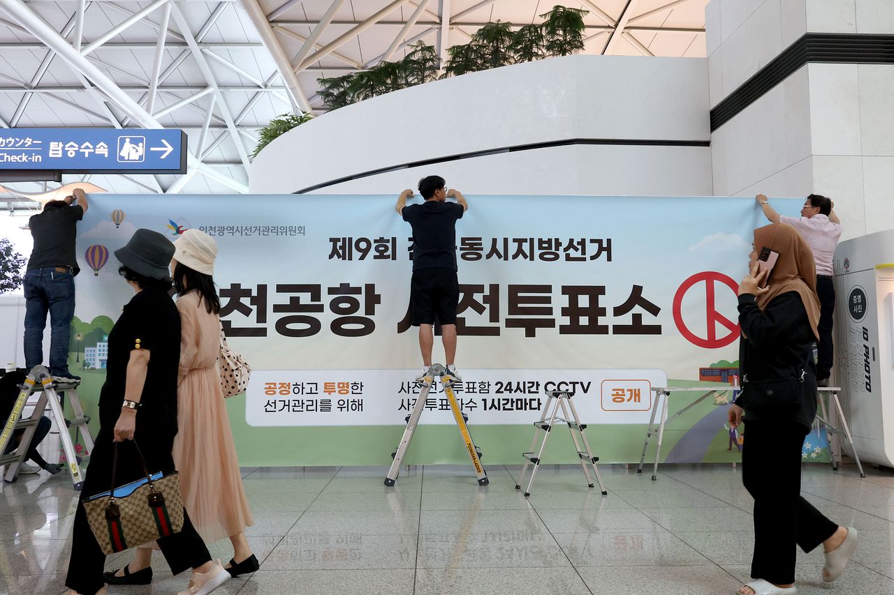 제9회 전국동시지방선거 사전투표를 이틀 앞둔 27일 오전 인천국제공항 1터미널에서 인천시선관위 관계자들이 사전투표소 설치작업을 하고 있다. 뉴스1