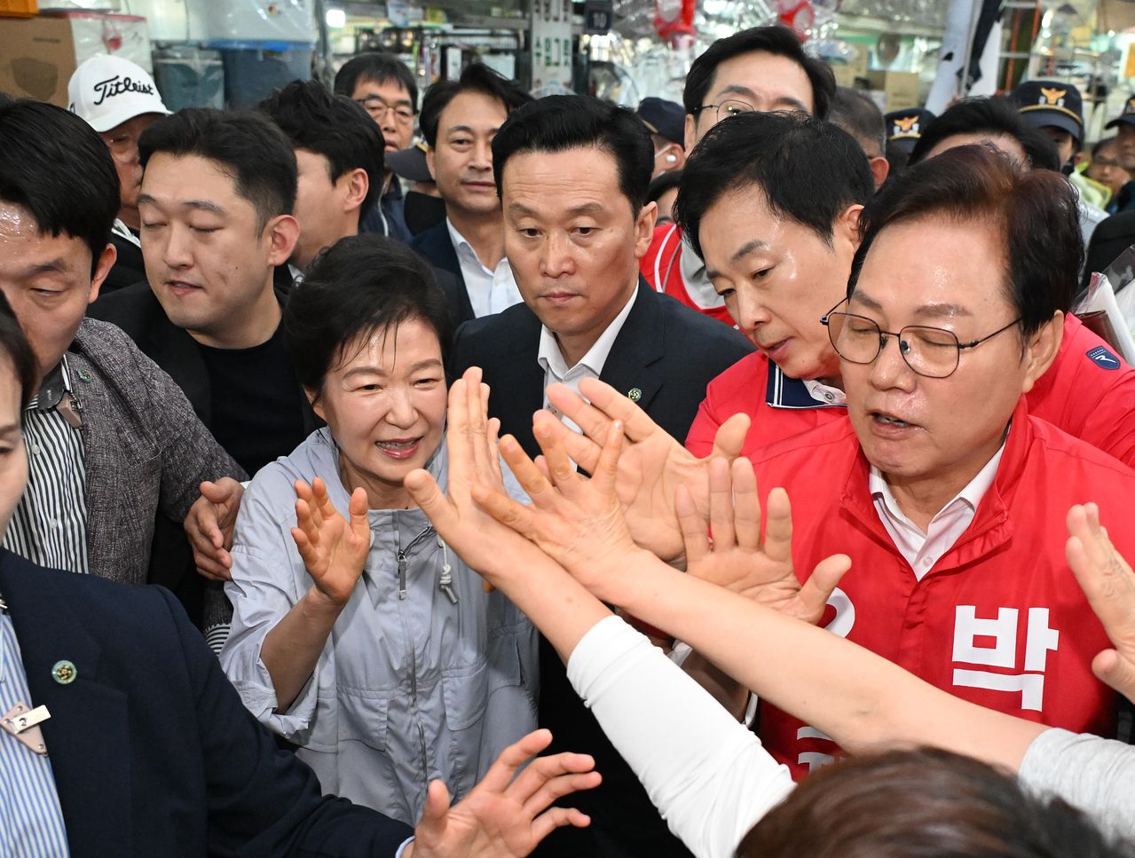 박근혜 전 대통령이 27일 경남 진주시 진주중앙시장을 찾아 시민과 인사하고 있다.   박 전 대통령은 이날 국민의힘 박완수 경남지사 후보, 같은 당 한경호 진주시장 후보 등을 지지하기 위해 진주를 방문했다. 연합뉴스