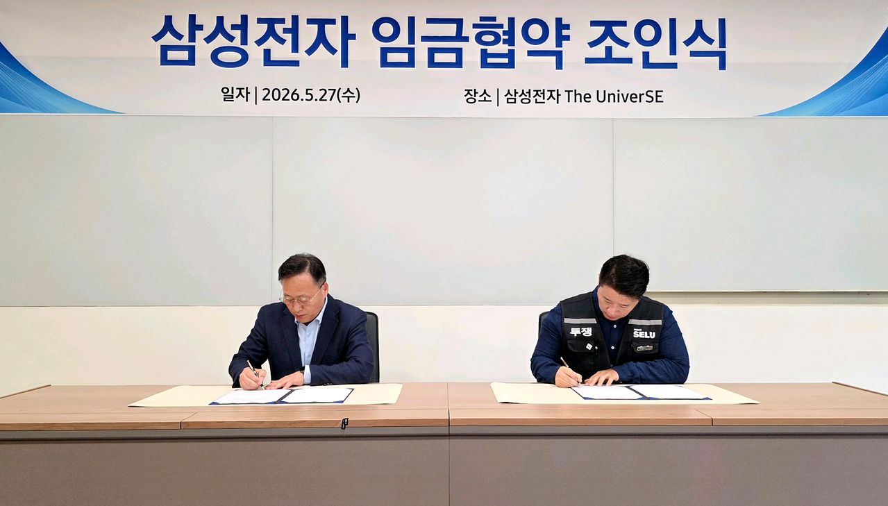 삼성전자 여명구 부사장(왼쪽)과 삼성그룹 초기업노동조합 삼성전자 지부 최승호 위원장이 27일 '2026년 임금협약 조인식'에서 서명하고 있다. 연합뉴스