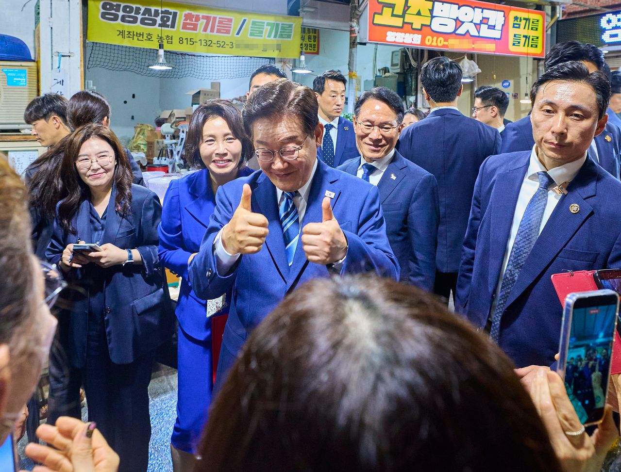 이재명 대통령과 김혜경 여사가 27일 부산 남항시장에서 시민들과 인사하고 있다. 사진 청와대=연합뉴스