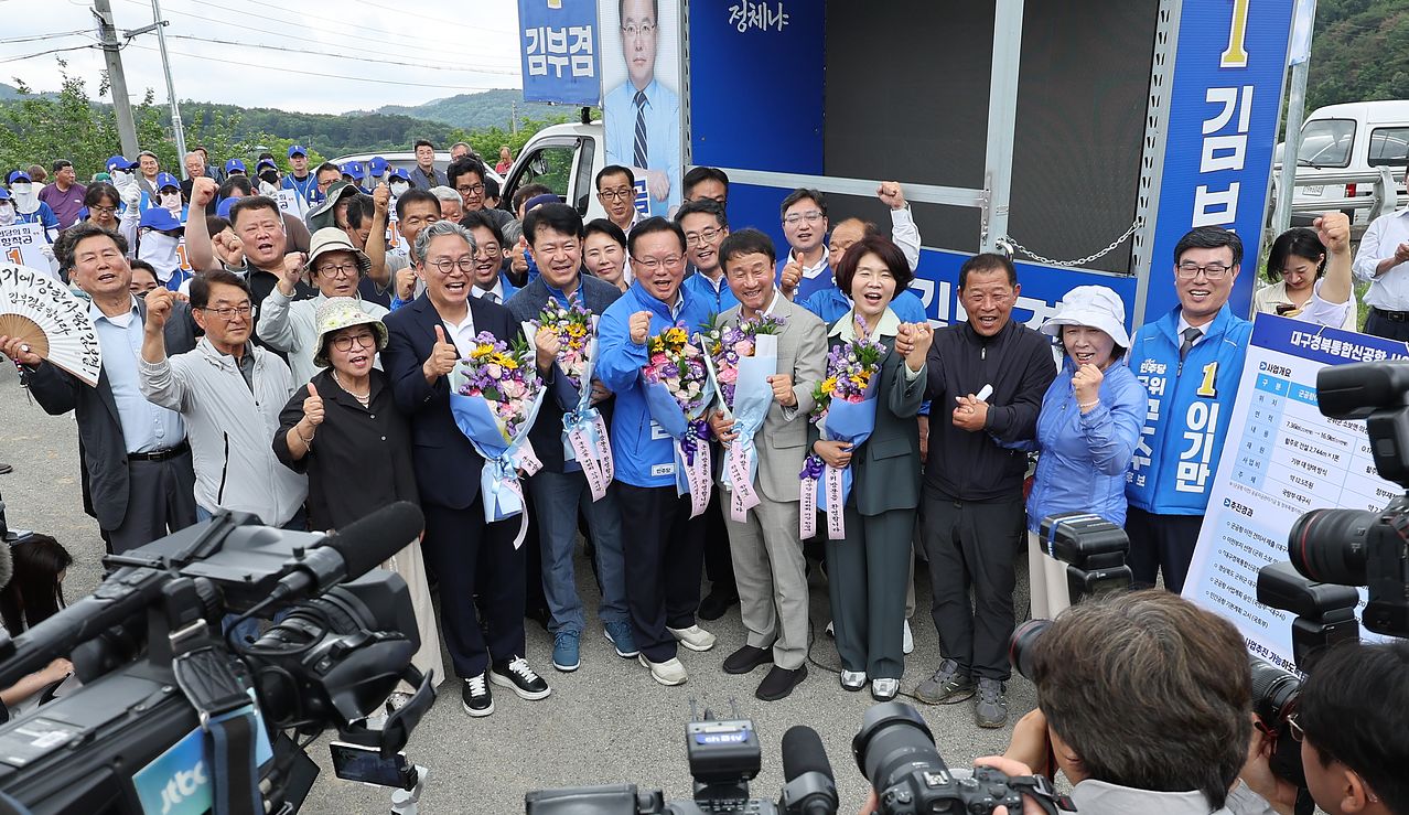 더불어민주당 한병도 원내대표와 김부겸 대구시장 후보가 28일 대구 군위군 대구경북신공항 부지를 찾아 파이팅을 외치며 기념 촬영을 하고 있다. 연합뉴스