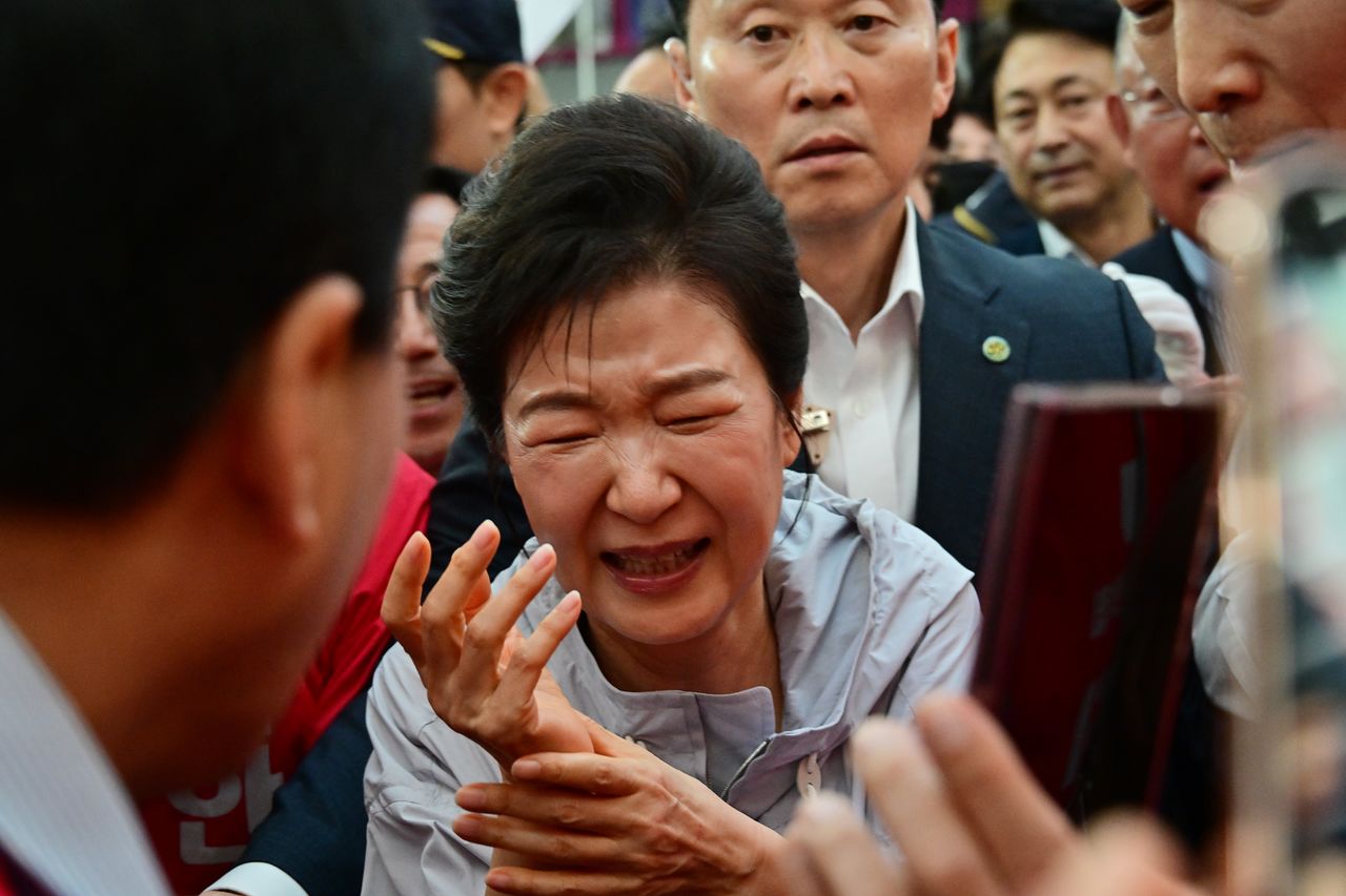 지난 27일 경남 진주시 중앙시장을 찾은 박근혜 전 대통령이 시민들과 악수를 한 후 고통스러운 표정을 짓고 있다. 뉴시스