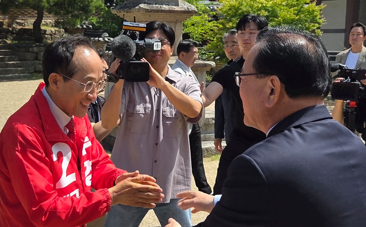 김부겸 더불어민주당 대구시장 후보와 추경호 국민의힘 대구시장 후보가 부처님오신날인 지난 24일 대구 대표 사찰인 동화사에서 열린 봉축법요식에 참석하기에 앞서 마주쳐 인사를 나누고 있다. 뉴스1