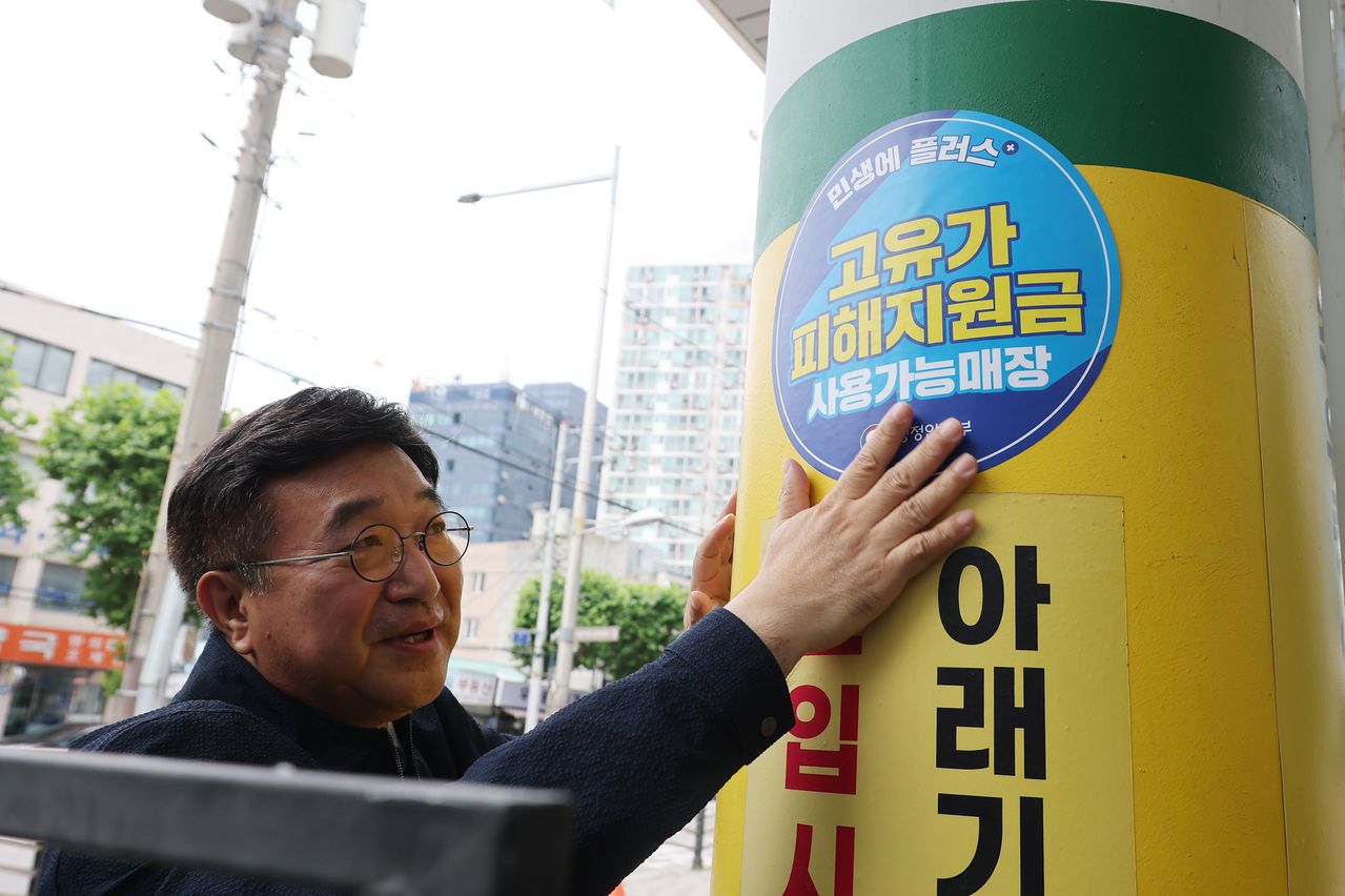 윤호중 행정안전부 장관이 19일 고유가 피해지원금 2차 사용처 현장 점검을 위해 서울 영등포구 한일주유소를 방문해 관련 안내 스티커를 붙이고 있다. 연합뉴스