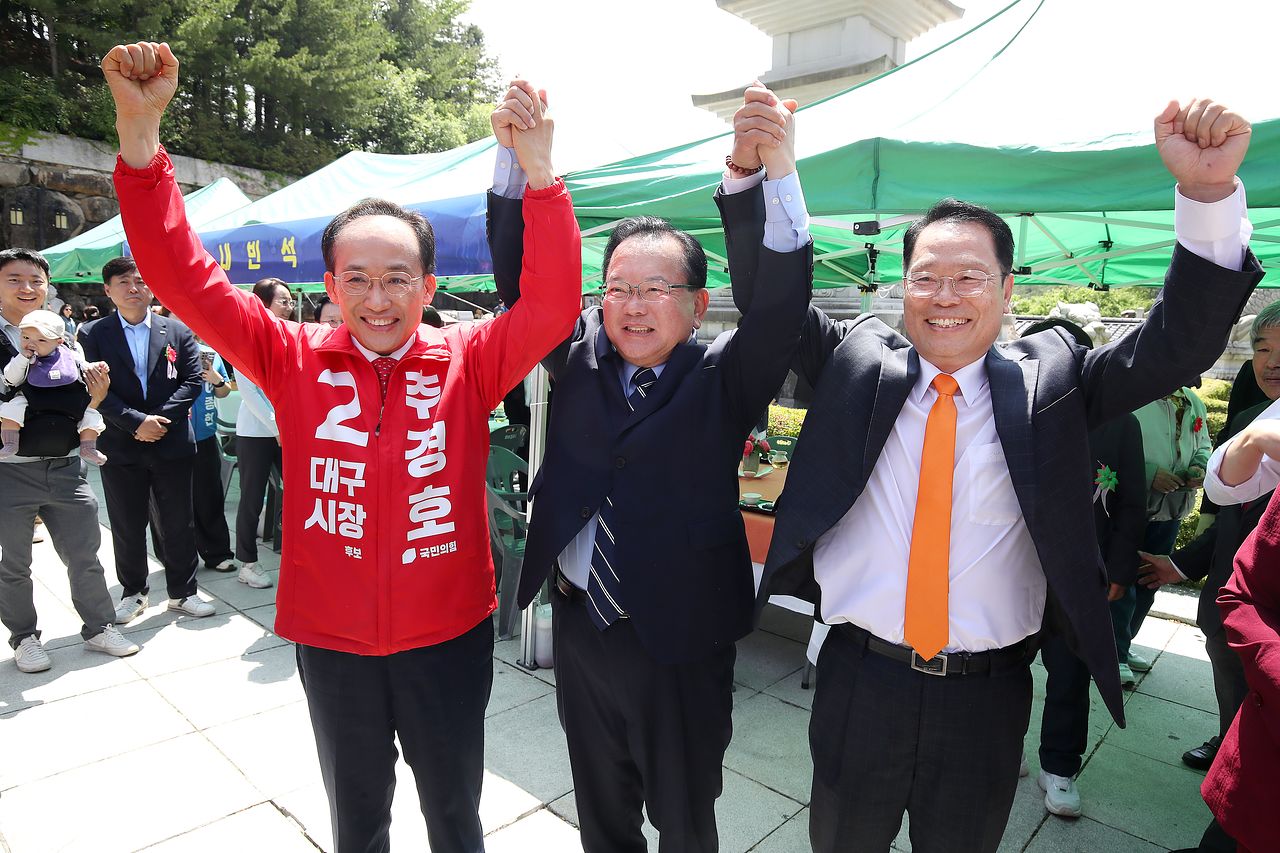 추경호 국민의힘 대구시장 후보, 김부겸 더불어민주당 대구시장 후보, 이수찬 개혁신당 대구시장 후보(왼쪽부터)가 지난 24일 부처님오신날을 맞아 대구 동구 동화사를 찾아 함께 손을 들어 보이고 있다.뉴스1