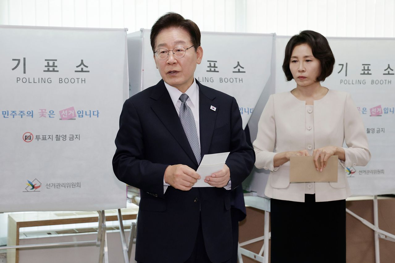 이재명 대통령이 제9회 전국동시지방선거 사전투표 첫날인 29일 서울 종로구 삼청동 주민센터에서 사전 투표 중 기표 도장 관련 문의를 하고 있다. 연합뉴스