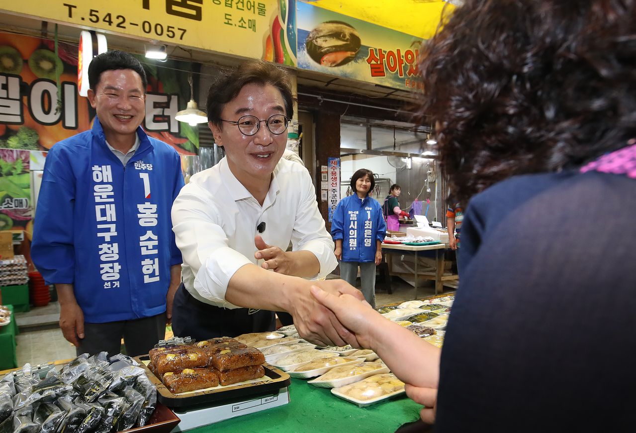 전재수 더불어민주당 부산시장 후보가 제9회 전국동시지방선거 및 국회의원 재보궐선거 사전투표 둘째 날인 30일 부산 해운대구 반송큰시장에서 상인에게 지지를 호소하고 있다. 뉴스1