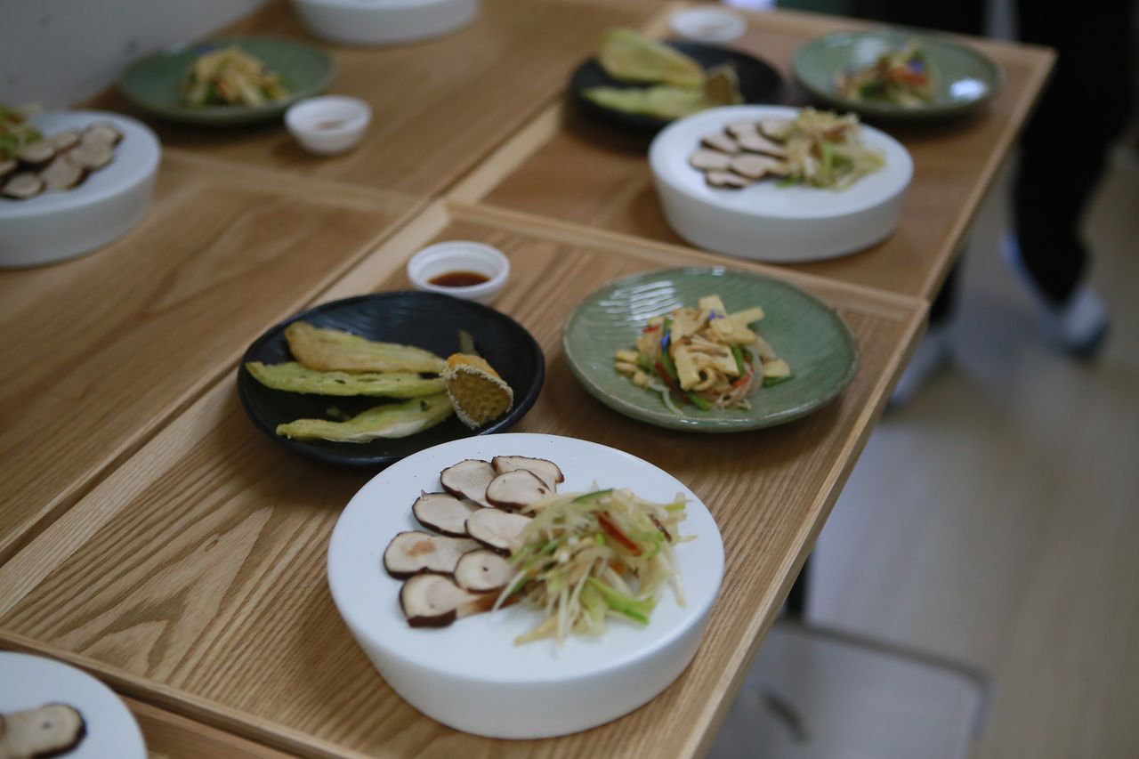 사찰음식으로 차린 파인다이닝의 일부분으로 연꽃잎튀김, 참송이수삼냉채, 홍시죽순채가 그릇에 담겨 있다. 사진 범어사 사찰음식연구소