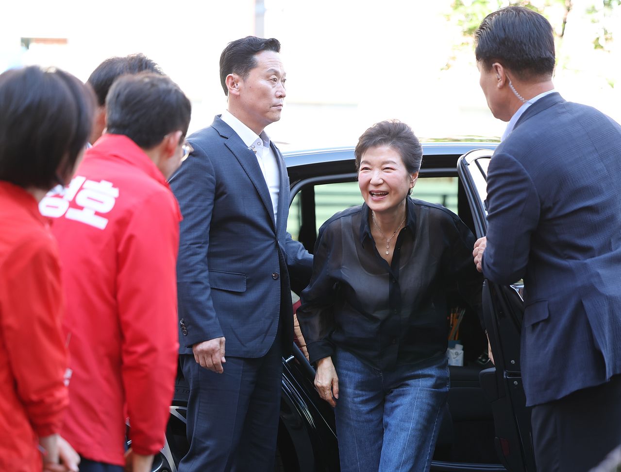 박근혜 전 대통령이 31일 오후 대구 중구 서문시장을 찾아 차량에서 내리며 추경호 국민의힘 대구시장 후보와 인사하고 있다. 뉴스1