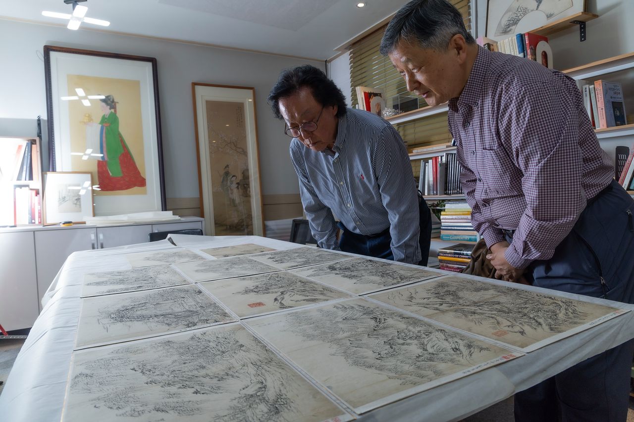 단원 김홍도(1745~1806?)가 금강산과 관동팔경 일대를 유람하고 그린 초본화첩 ‘해동명산도첩’ 중 누락됐던 10점이 발견됐다. 조선 마지막 어진화가였던 이당 김은호(1892~1979)의 유품 창고 속에서다. 지난달 20일 서울 성북구에 위치한 이당 김은호 기념사업회 사무실에서 김은호의 아들 김성원씨(왼쪽)와 단원 전문가 진준현 전 서울대박물관 학예연구관이 작품들을 살펴보고 있다. 권혁재 사진전문기자