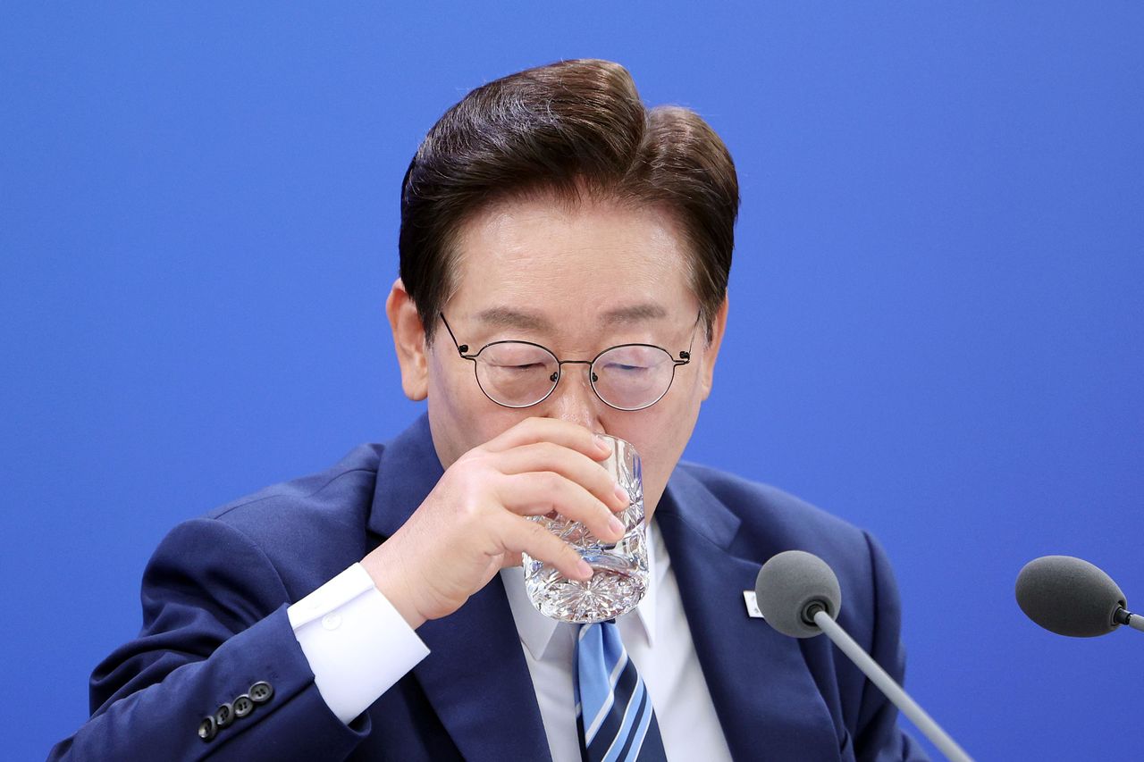 이재명 대통령이 지난달 27일 부산 해운대구에서 열린 제48차 유네스코 세계유산위원회 개최 준비 현황 보고회에서 물을 마시고 있다.   이 대통령은 이 보고회에서 BTS 부산 공연을 언급하며 바가지 문제 등 개선을 주문했다. 사진 연합뉴스