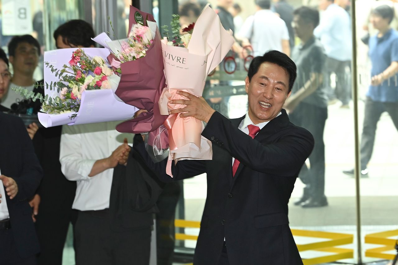 오세훈 서울시장이 4일 서울시청으로 출근하며 직원들이 준비해 준 꽃다발을 받고 기뻐하고 있다. 연합뉴스