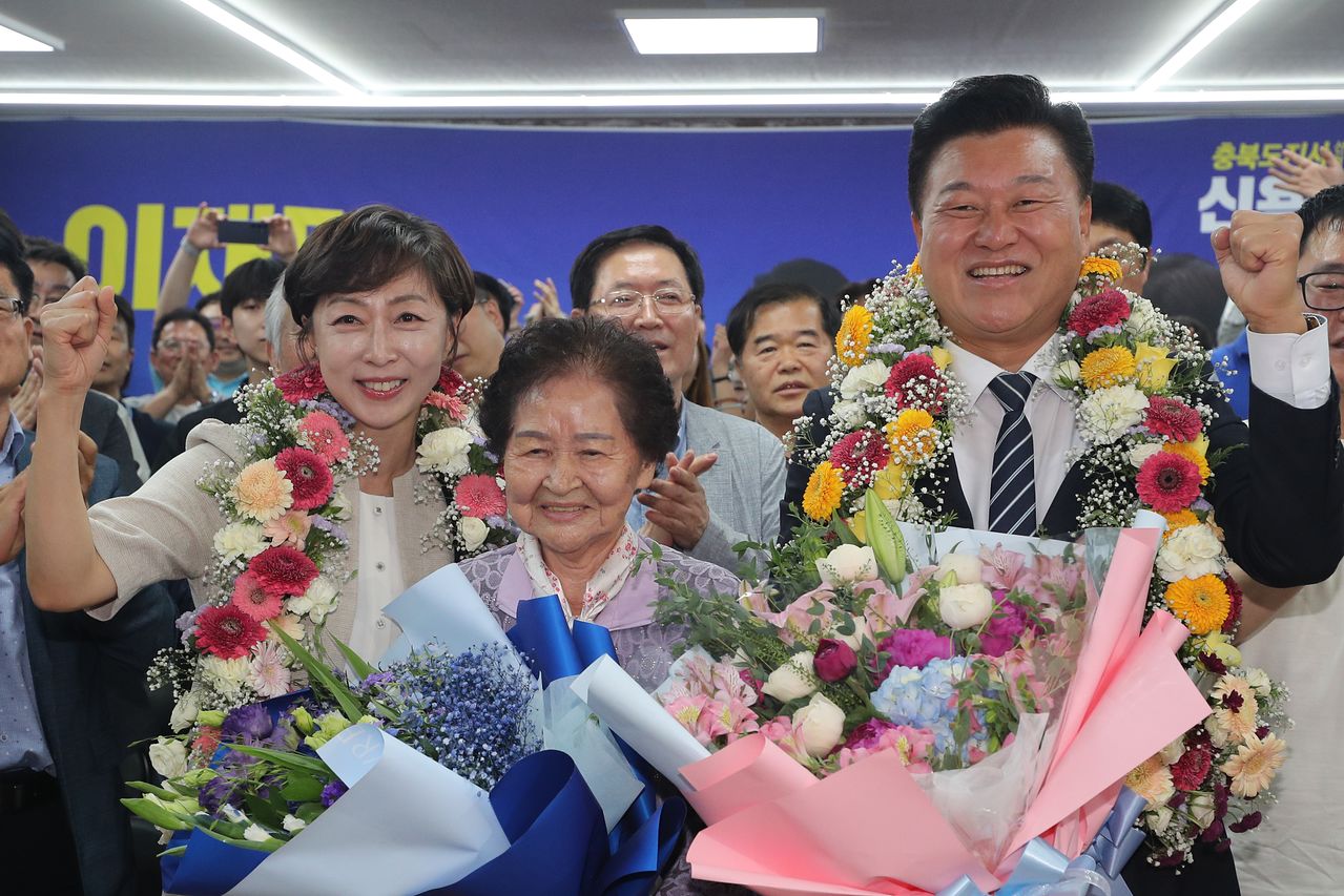 더불어민주당 신용한 충북지사 당선인(오른쪽)과 그의 어머니, 배우자 이채영 씨가 지난 3일 오후 11시 40분쯤 충북 청주시 흥덕구 선거사무소에서 당선이 유력시되자 꽃목걸이를 걸고 세리머니를 하고 있다. 뉴스1